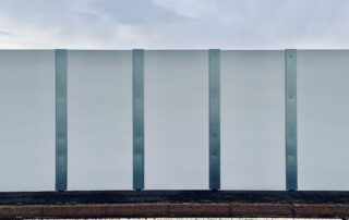 An image of tall white imposing hoardings at Princes Parade, Hythe.