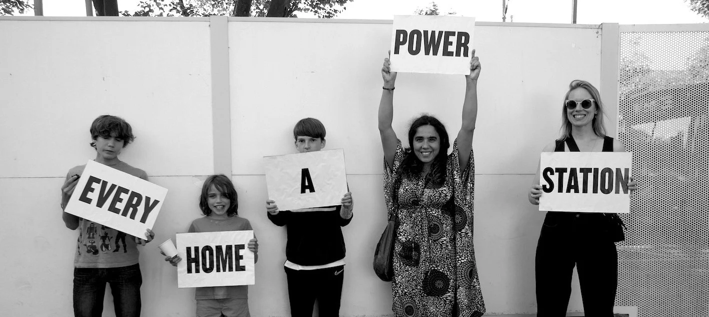 Five people holding signs reading "Every home a power station"